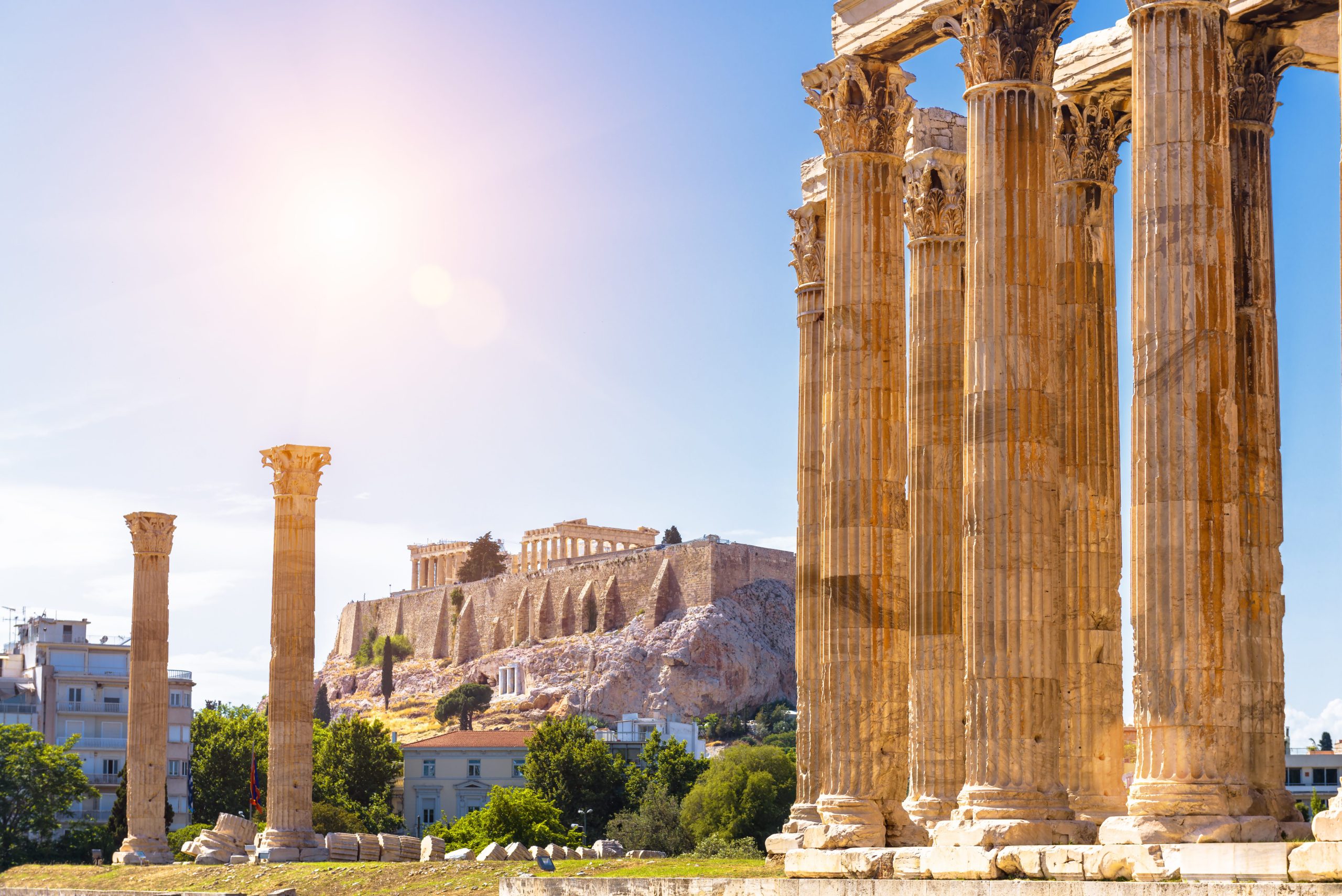 Zeus temple overlooking Acropolis, Athens, Greece. These are famous landmarks of Athens. Sunny view of Ancient Greek ruins, great columns of classical building in Athens city center. Travel concept.
